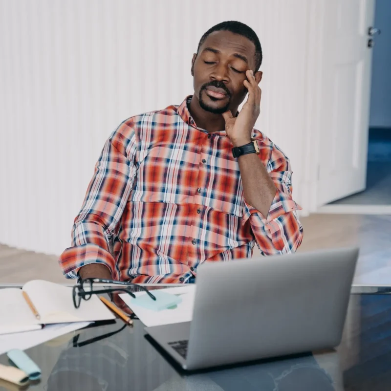 Does nyquil make you sleepy? Sleepy man sitting at office desk.